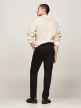 Pantalón chino negro de Tommy Hilfiger, modelo Denton, con pierna recta y confeccionado en satén de algodón elástico. Cuenta con cierre de cremallera con botón, dos bolsillos ribeteados en la cintura y dos bolsillos traseros de ojal con botón. Logo de Tommy Hilfiger bordado en la parte trasera.