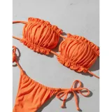 Bikini de dos piezas color naranja vibrante, confeccionado en licra. El top es tipo bandeau con diseño plisado y tiras finas, mientras que la parte inferior es tipo tanga con laterales ajustables mediante lazos.