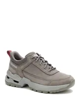 Championes Caterpillar modelo Surge Hiker Lo, color gris oscuro, confeccionados en nubuck encerado y malla. Presentan diseño robusto con entresuela de EVA, suela de goma con tecnología SRX para resistencia al deslizamiento y amortiguación reactiva.