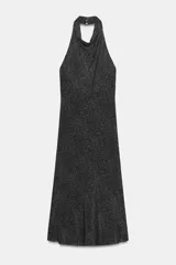 Vestido midi con cuello halter fluido y hombros descubiertos. Presenta un diseño de espalda descubierta, corte evasé y cierre con botones en el cuello. Confeccionado en una mezcla de algodón y viscosa con estampado de lunares pequeños.