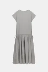 Vestido midi de Zara Woman Collection confeccionado en hilatura con lino, color gris. Presenta cuello redondo, manga corta caída, detalle de frunces y lazadas laterales en el mismo tejido, y cierre en la espalda.