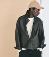 Campera de estilo urbano confeccionada en poliuretano con acabado lavado y textura que imita el cuero. Presenta cuello inglés, cierre frontal con cremallera, vista con botones y bolsillos delanteros amplios.