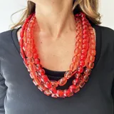 Collar de varias vueltas con cuentas de resina translúcida color rojo y naranja, con diferentes formas y tamaños.