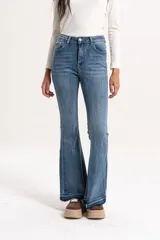 Jean de corte semi oxford y tiro medio, confeccionado en denim azul. Presenta un diseño con bajo deshilachado y terminación sin dobladillo.