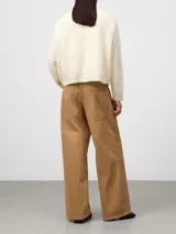 Pantalón de denim color camel con corte barrel fit, pierna ancha y pinza bajo la rodilla. Cuenta con cierre de botón metálico, trabillas para cinturón, cinco bolsillos y canesú en la espalda.