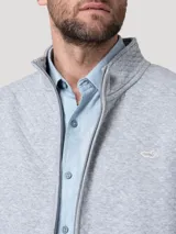 Chaleco gris melange con textura acolchada de rombos, cuello alto y cierre frontal de cremallera. Presenta un pequeño parche bordado con silueta de pato en el pecho.