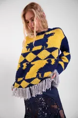 Sweater de lana merino tejido a mano con diseño geométrico y figuras de llamas, corte holgado con cuello redondo y flecos decorativos en el ruedo.