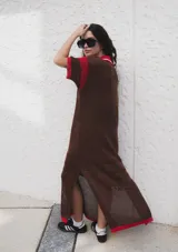 Remerón tejido de punto color azul marino con calados, cuello estilo camisa en verde oscuro con rayas blancas y verdes, y logo bordado en blanco en el pecho.