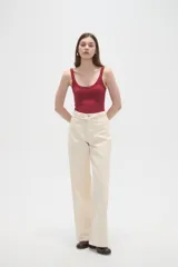 Pantalon de jean de corte ancho y tiro medio, en color natural, con cierre frontal y bolsillos laterales.