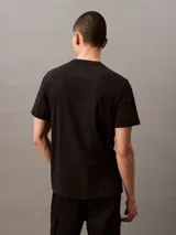 Remera negra de manga corta con estampado del logo de Calvin Klein Jeans en color blanco.