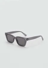 Gafas de sol con montura cuadrada de policarbonato reciclado en color gris traslúcido y cristales oscuros con protección UV categoría 3.