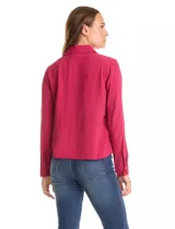 Camisa de crepe color beige con cuello clásico, cierre frontal con botones y dos bolsillos aplicados en el pecho.