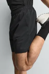 Pantalones deportivos cortos de Zara Athleticz, confeccionados en tejido técnico ligero y elástico. Presentan cintura elástica ajustable con cordón interior, bolsillos frontales, bajo con perforaciones decorativas y aberturas laterales, con detalle de logo estampado en la pierna.
