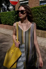 Vestido midi sin mangas con cuello en V, de corte holgado y diseño de parches con rayas verticales y horizontales en tonos verdes, grises y blancos.