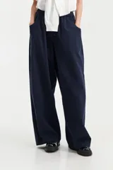 Pantalón ancho de tiro bajo color azul marino, con cintura elástica y cierre frontal de botones visibles.