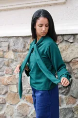 Blusa verde de manga larga con cuello tipo lazo, confeccionada en tela con textura ligera y corte recto.