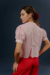 Blusa de algodón a rayas rosadas y blancas, con mangas cortas abullonadas, cuello mao y detalles de tela estampada floral en la botonera y los puños.