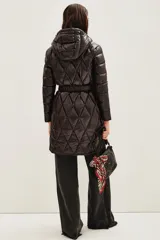 Campera puffer larga de color negro con diseño acolchado en forma de rombos. Cuenta con capucha, cierre frontal, bolsillos con cierre y un cinturón elástico con hebilla metálica en la cintura.