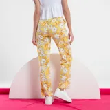 Pantalón de mujer color beige con estampado floral en amarillo y blanco, de corte recto y tiro alto.