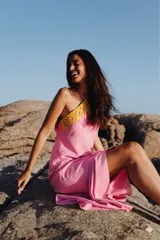 Vestido largo de lino color rosado, con escote halter y detalle de guarda pampa en cuero amarillo en la parte superior.