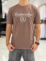 Remera marrón de manga corta con cuello redondo y estampado frontal en color blanco con el texto "Duxonstudios" y un logotipo rodeado por una corona de laureles.