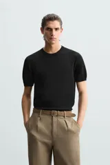 Camiseta negra de punto con cuello redondo, manga corta y corte regular. Tejido de viscosa con acabado en rib.