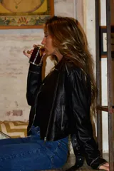 Chaqueta de cuero sintético marrón, tipo biker, con cierre frontal cruzado, solapas con muesca y bolsillos laterales con cierre.