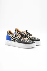 Zapatillas acordonadas con estampado de cebra, detalles en cuero negro y azul, y suela de plataforma blanca.
