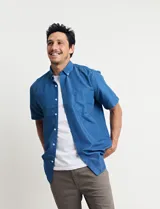 Camisa azul con estampado de lunares blancos, de manga corta y corte clásico.