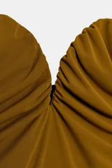 Body de estilo halter con escote corazón y detalle de tejido drapeado en el frente. Presenta espalda descubierta y cierre inferior con botones a presión.