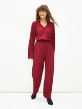 Pantalón de vestir color borgoña, de corte palazzo y tela plisada.