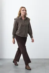 Pantalón de pana color marrón chocolate, de corte recto con bolsillos laterales y cierre frontal.