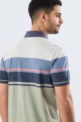 Remera polo de manga corta con diseño a rayas horizontales en tonos beige, celeste, rosado, azul marino y verde. Cuenta con cuello polo y cierre frontal con botones.