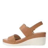 Sandalias de plataforma con diseño de tiras en cuero sintético color tostado. La tira delantera presenta una textura grabada, mientras que la tira trasera incluye un cierre con hebilla y detalle metálico. Posee una base de plataforma blanca con diseño estriado.