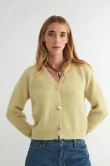 Cardigan de punto color verde claro, con escote en V, manga larga y cierre frontal con tres botones grandes en tono dorado.