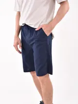Bermuda azul marino de corte clásico, con bolsillos laterales y cintura elastizada con cordón ajustable.