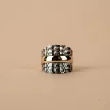Anillo ancho de diseño mixto, compuesto por dos bandas laterales de plata 925 con acabado martillado y una banda central lisa de oro amarillo.
