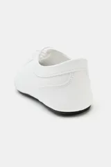 Zapatilla deportiva estilo blucher de color blanco, con cordones del mismo tono, pespuntes decorativos y suela plana con base negra.