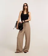 Pantalón wide leg color beige con textura, cintura elástica con cordón ajustable y bolsillos laterales.