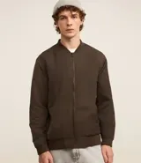 Campera bomber color beige, con cuello alto, cierre frontal con cremallera, bolsillos laterales y puños y cintura elastizados.