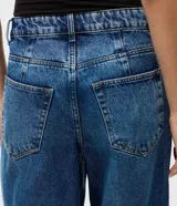 Pantalón de jean Blue Steel modelo baggy, de corte recto y amplio con cintura media. Presenta un lavado uniforme, cierre frontal con botón y cremallera, presillas para cinturón y bolsillos funcionales.