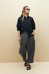 Camisa blanca de manga larga con cuello camisero y botones de nácar. Presenta detalle de broderie en el canesú y las mangas.