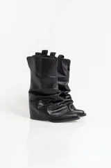Botas texanas de cuero negro con diseño de caña arrugada y puntera fina. Presentan un taco cuadrado de altura media y tiradores laterales en la parte superior de la caña.