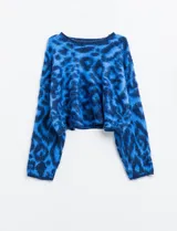 Buzo de lana con cuello redondo, manga larga amplia y corte crop. Presenta un estampado animal print en tonos de azul vibrante.