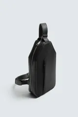 Bandolera negra de formato vertical con textura, diseño geométrico y correa ajustable para llevar al hombro.