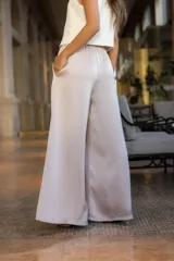 Pantalón palazzo color beige de tiro alto y corte amplio.