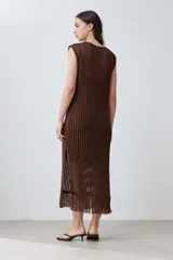 Vestido marrón de tejido calado, corte recto, largo midi, sin mangas y con flecos en el ruedo.