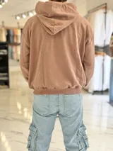 Hoodie de corte boxy fit color gris, con capucha y estampado frontal con la leyenda "Duxon Creative Studios".