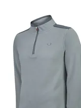 Buzo polar Roots color gris, de manga larga, con cuello alto y medio cierre frontal. Presenta detalles en color gris oscuro en el cuello, hombros y bordes del cierre, además de un pequeño logo bordado en el pecho.