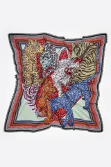 Chal cuadrado confeccionado en modal con un diseño estampado de diversos felinos, como tigres y leopardos, dispuestos en forma de corazón sobre un fondo rojo. Presenta bordes decorativos con marcos en contraste y terminaciones desflecadas.